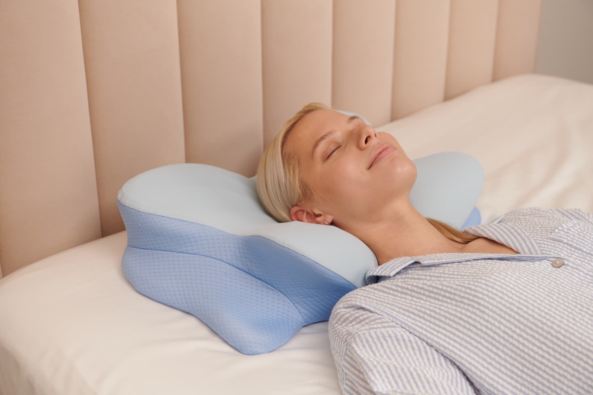 Woman sleeping on her back on the Derila Ergo butterfly pillow